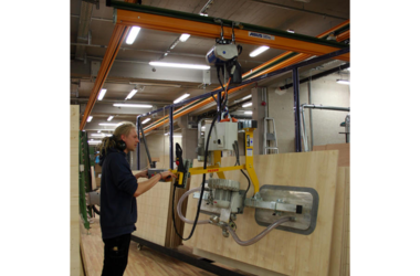 Arbeider vervoert houten planken voor het decor met behulp van de ABUS-kraan 