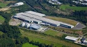 Luchtfoto van het terrein van ABUS Kransysteme GmbH met productiehallen voor bovenloopkranen en componenten en het KranHaus in Herreshagen