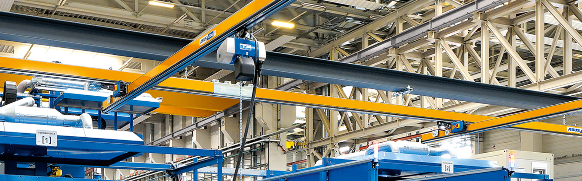 ABUS-hangbaan met enkele ligger EHB in een moderne industriële hal voor het vervoeren en hijsen van lasten.
