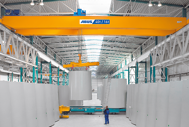 ABUS-tweebalkenloopkraan in een industriële hal met een draagvermogen tot 120 ton en een overspanning tot 42 meter voor het vervoer van zware lasten.