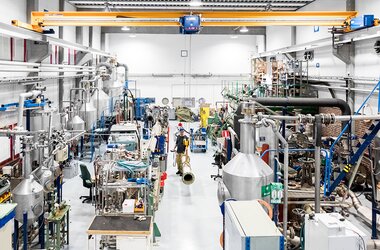 Moderne productiehal met industriële machines en een ABUS-kraaninstallatie voor nauwkeurig materiaaltransport.